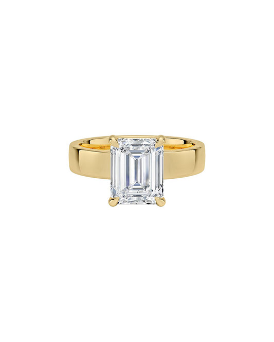 Gold ring with a large emerald-cut diamond on a white background