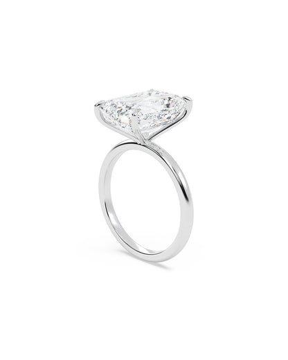 Diamond ring with an emerald cut stone on a white background