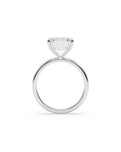 Diamond ring with an emerald-shaped center stone on a white background