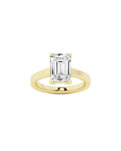 Yellow gold ring with an emerald-cut diamond on a white background