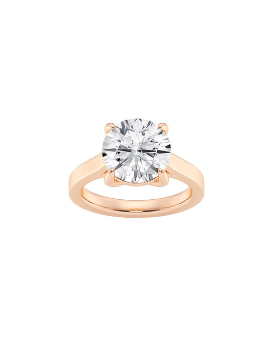 Rose gold ring with a round cut diamond on a white background