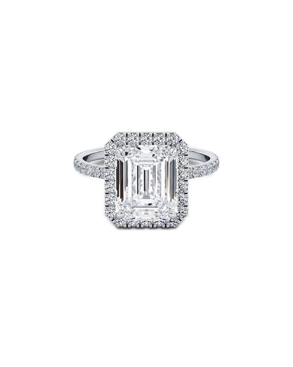 Diamond ring with emerald-cut center stone on a white background