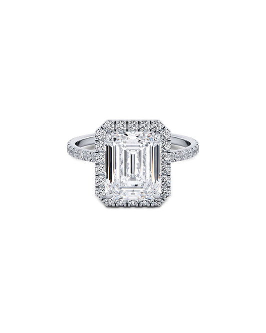 Diamond ring with emerald-cut center stone on a white background