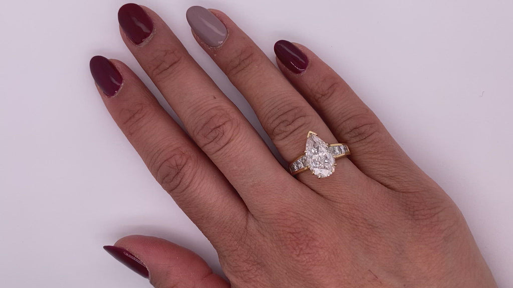 Diamond Ring Pear Shape Cut 4 Carat Sidestone Ring in 18K Yellow Gold Video on Hand