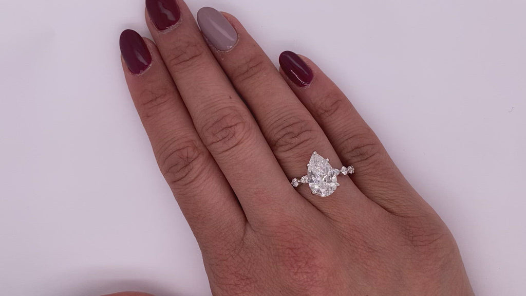 Diamond Ring Pear Shape Cut 4 Carat Sidestone Ring in 18K White Gold Video on Hand