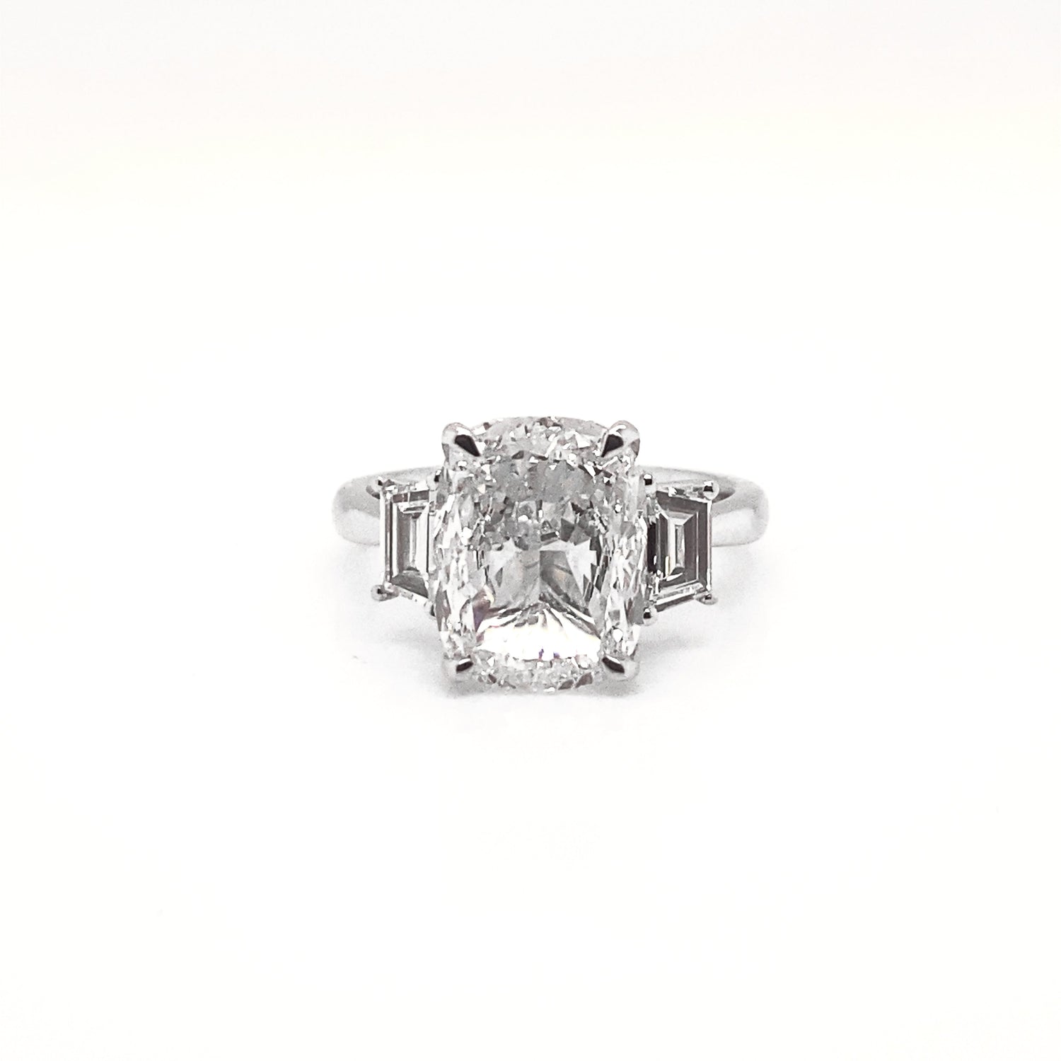Nekta New York elegant three stone cushion cut ring with a large central diamond and two side stones